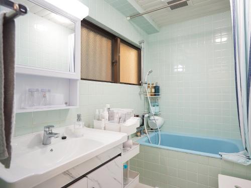 那霸Guest house II Rokumarukan的浴室配有盥洗盆和浴缸。