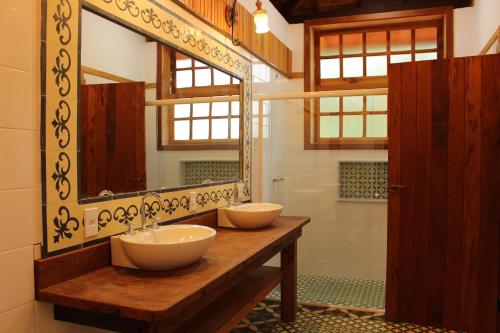 巴纳纳尔Fazenda Capuava的一间带两个盥洗盆和大镜子的浴室