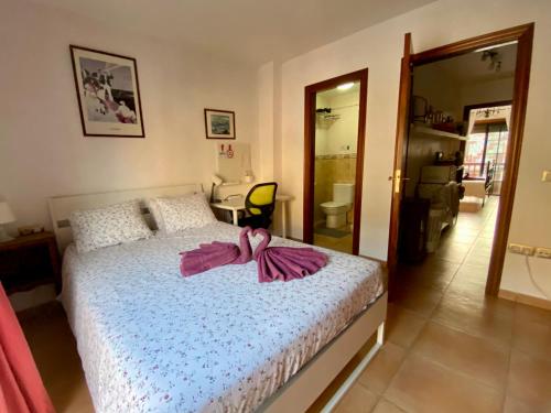 厄尔梅达诺Bedroom Medanomar 1的一间卧室配有一张带粉红色浴袍的床