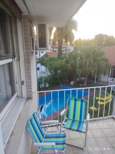 奥利沃斯hostel olivos的阳台设有两把椅子和游泳池