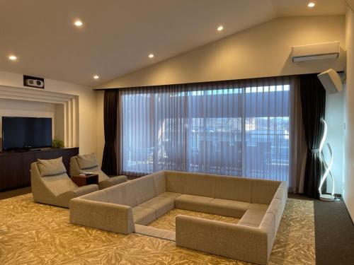 轻井泽轻井泽韦尔久大酒店的带沙发和大窗户的客厅
