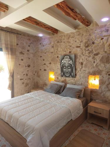 索维拉Villa ichawin的一间卧室设有一张大床和石墙