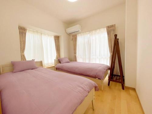 名户北部観光アクセス良好な新築貸別荘／最大4名ベッド4台／Wi-Fi／海岸線近く的一间卧室设有两张床和窗户。