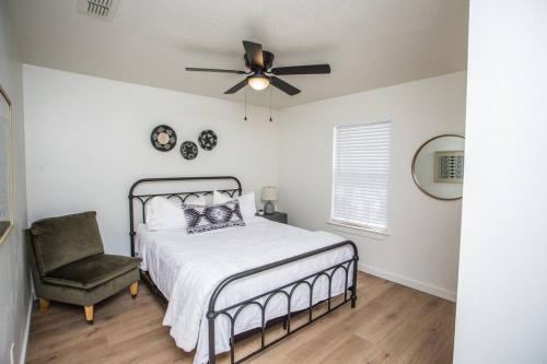 拉伯克7 beds Relax by Texas Tech & Hospitals Sleeps 10的卧室配有1张床、吊扇和1把椅子