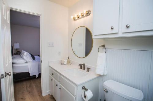 拉伯克7 beds Relax by Texas Tech & Hospitals Sleeps 10的一间带水槽和镜子的浴室以及一张床