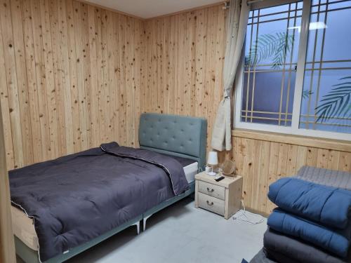 济州市Amy House的卧室配有床、椅子和窗户。