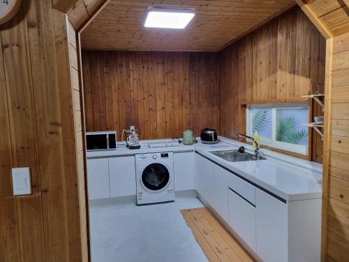 济州市Amy House的厨房配有洗衣机和水槽