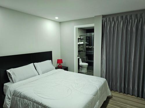 昆卡apartamento de lujo的一间带白色大床的卧室和一间浴室