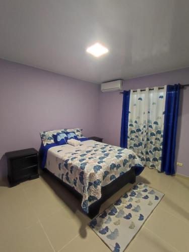 FantinoCoral的一间卧室配有床和蓝色窗帘的窗户