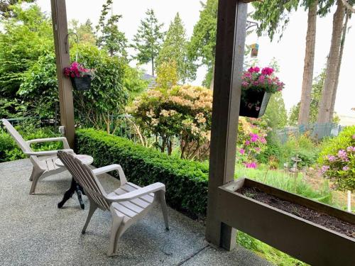 纳奈莫Waterfront Eagle Nest的花园内带两把椅子和鲜花的庭院