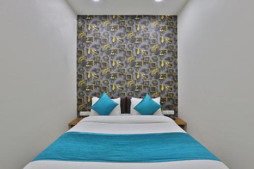 艾哈迈达巴德Hotel Shivaay的一间卧室配有蓝色和黄色枕头的床
