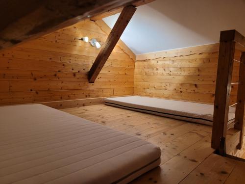莱鲁斯7 p - Au cœur du massif jurassien的木制客房内的一间卧室配有两张床