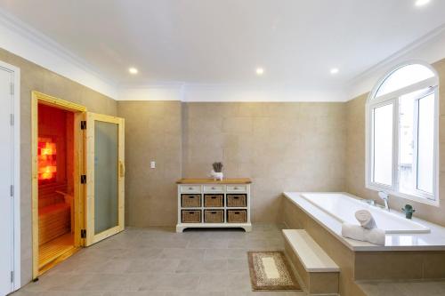 岘港L'amour Villa - Sauna & Pool的带浴缸和窗户的大浴室