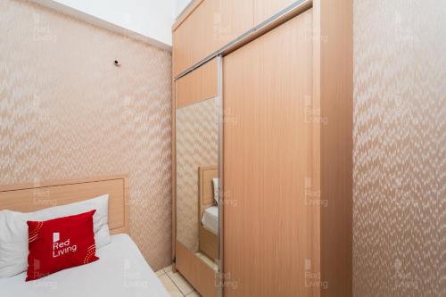 万隆RedLiving Apartemen Tamansari Panoramic - Rasya Room with Netflix的小房间,配有一张红色枕头的床