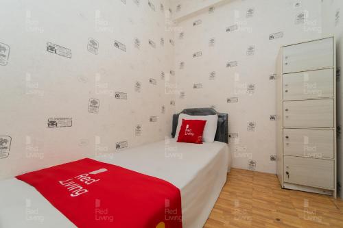 万隆RedLiving Apartemen Tamansari Panoramic - Rasya Room with Netflix的一间卧室配有一张床铺,床上铺有红色毯子