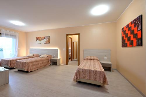 蒙法尔科内意大利酒店的一间酒店客房,设有两张床和走廊