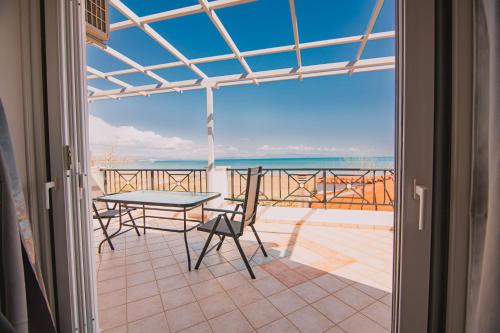 卡塔科隆Villa Olga Sea Front Katakolo - Happy Rentals的一个带桌椅的海景阳台