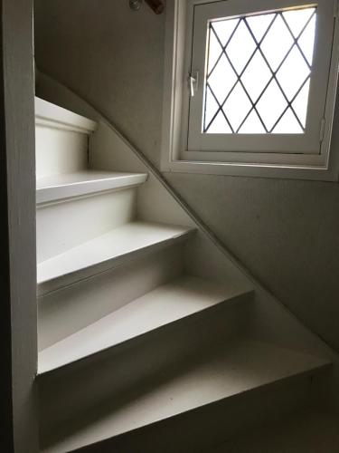 韦斯特多珀Aangename en zeer rustig gelegen vakantiewoning的一个带窗户和白色架子的楼梯