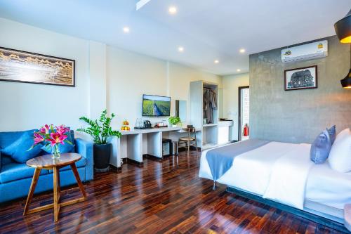 贡布Rainforest Hotel by NSUN的酒店客房,配有床和蓝色的沙发