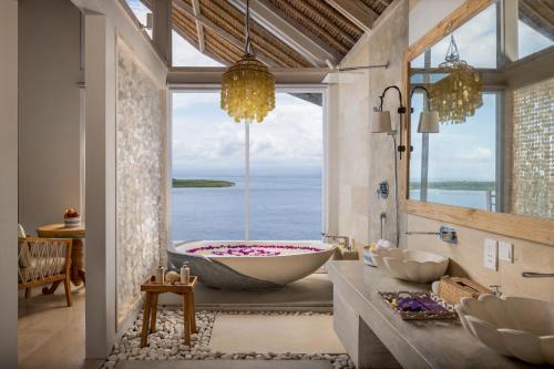 珀尼达岛Pramana Natura Nusa Penida的带浴缸的浴室,享有海景