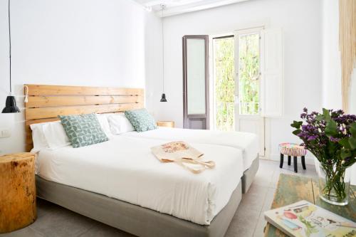 巴塞罗那格劳生态精品酒店的卧室配有一张白色大床和木制床头板