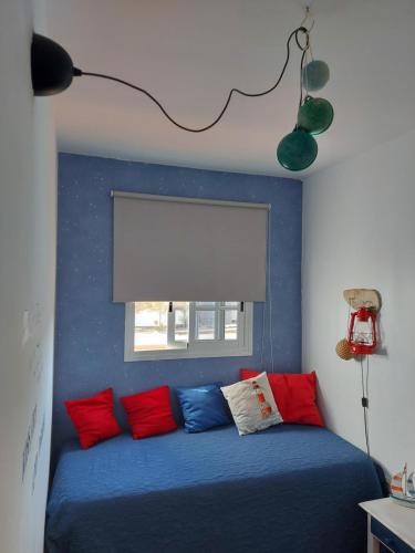 罗萨里奥港Casa Elsa的一间卧室配有蓝色的床和红色和蓝色枕头