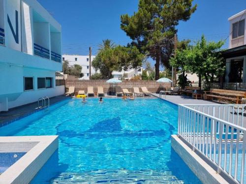 帕福斯NEREUS HOTEL By IMH Europe Travel and Tours的大楼内的一个蓝色海水游泳池