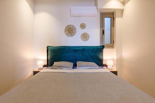 雅典Goudi 4th Floor Greece Apartments的一间卧室配有一张床,墙上挂着两盏灯和两盘盘子