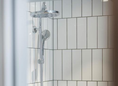 马尔默UNITY Malmö的浴室铺有白色瓷砖,设有淋浴。