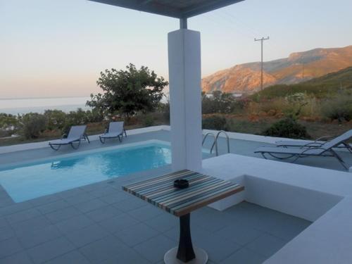 斯基罗斯岛Grand Villa Lino的一个带两把椅子和一张桌子的游泳池