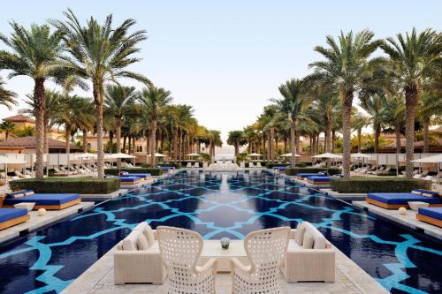 迪拜迪拜奥尼乐帕姆酒店的一个带椅子的游泳池,棕榈树