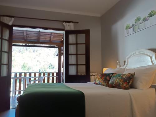 吉尔斯São Miguel do Gerês的一间卧室设有一张床,另一扇门设有阳台