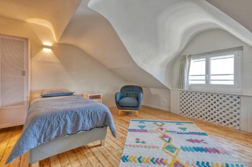 波尔尼谢Superbe appartement bord de mer的一间卧室配有床、蓝椅和地毯