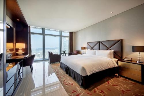 仁川市仁川奥卓豪景酒店公寓的一间卧室配有一张床、一张书桌和一个大窗户