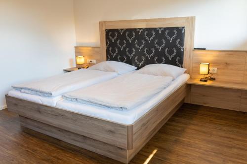 EmbachDorfleben Embach的一张大床,位于带两盏灯的房间