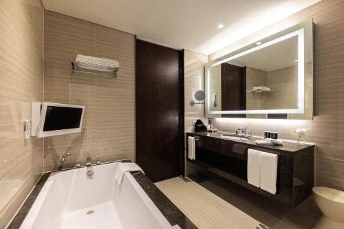 仁川市仁川奥卓豪景酒店公寓的带浴缸、水槽和镜子的浴室