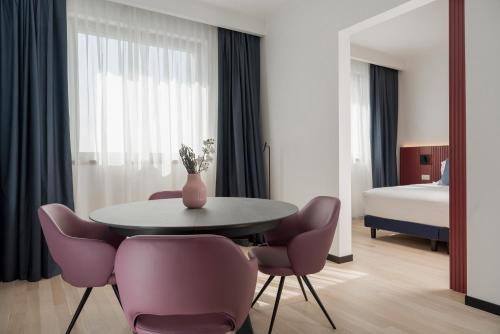 博洛尼亚Mitico Hotel & Natural Spa的配有桌椅和床的房间
