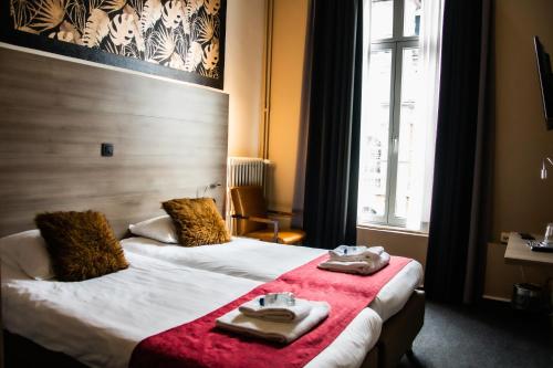 鲁汶工业酒店的酒店客房,配有两张带毛巾的床