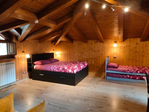 莫尔曼诺B&B Il Ghiro-Country House的木墙客房的两张床