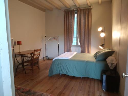 洛特河畔卡斯泰尔莫龙Lulu的一间卧室配有一张床、一张桌子和一个窗户。