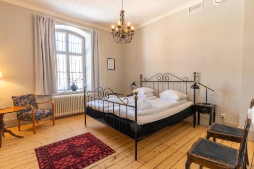 于默奥格姆拉番格尔塞特酒店的一间卧室配有一张床、一把椅子和一个吊灯。