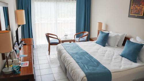 卡尔坎Happy Hotel Kalkan的一间卧室配有一张带蓝色枕头的大床