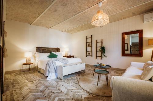 蒙巴鲁佐拉维拉酒店的一间卧室配有一张床、一张沙发和一张桌子