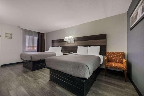 加兹登Quality Inn Gadsden - Attalla的酒店客房,配有两张床和椅子