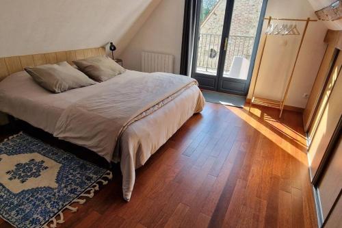 Jardins de Mélusine - Maison en pierres的一间卧室配有一张床,铺有木地板