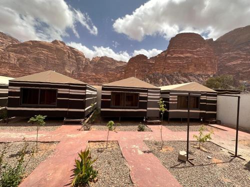 瓦迪拉姆Wadi Rum Oryx Hostel & Tours的几座山前的建筑物