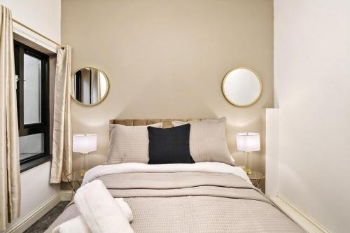 KentStylish 2BR Luxury Retreat with 65" Smart TV的卧室配有一张床铺,墙上挂有两面镜子
