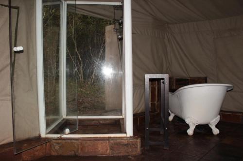 钦查Inkwenkwezi Private Game Reserve的帐篷内窗户旁的浴缸