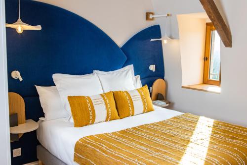 AltillacCueillette的一间卧室配有一张大床和蓝色床头板