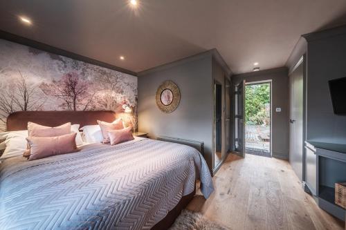 ClaveringThe Cricketers Clavering的卧室配有一张带粉红色枕头的大床